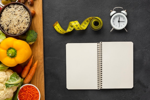 Photo gratuite planche à découper avec épicerie et maquette de cahier