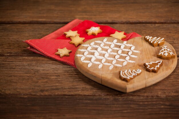planche à découper en forme de coeur avec des biscuits sur une serviette rouge