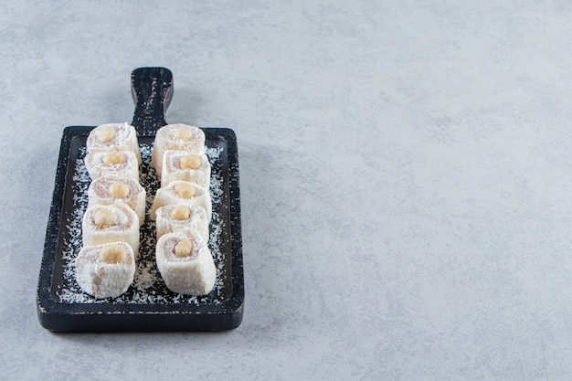 Planche à découper noire de délicieuses friandises aux noix sur fond de pierre.