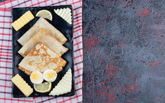 Planche De Petit-déjeuner Avec Crêpes, Fromage, Citron Et œufs.