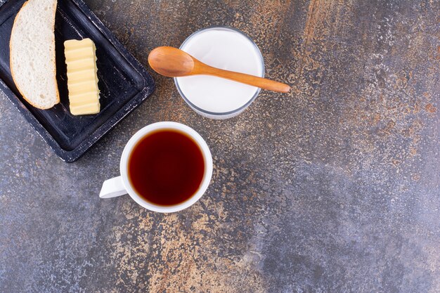 Planche de petit-déjeuner avec du pain et une tasse de thé