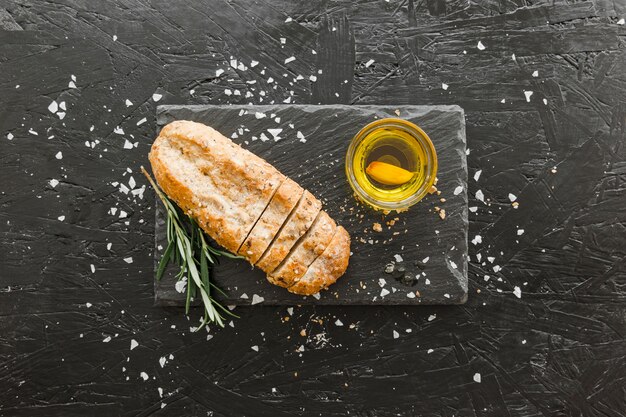 Photo gratuite planche de pierre avec du pain et de l'huile