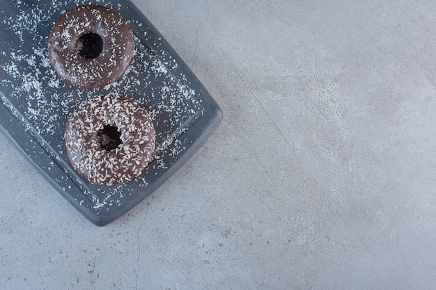 Planche sombre de délicieux beignets au chocolat sur fond de pierre.