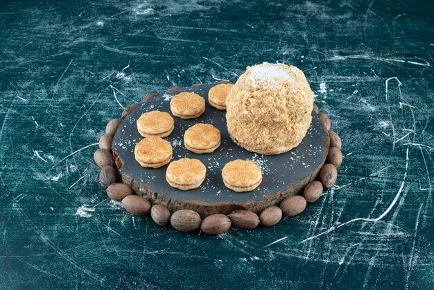 Une planche sombre avec des gâteaux et des biscuits sur un fond coloré. photo de haute qualité