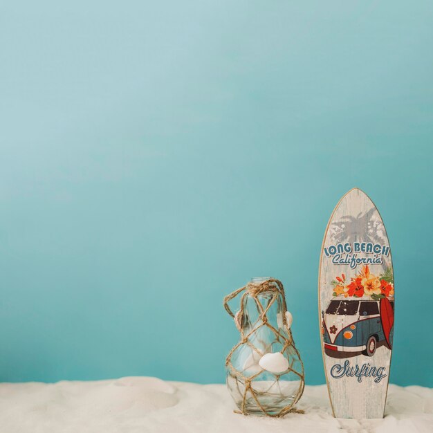 Planche de surf et bouteille sur fond bleu