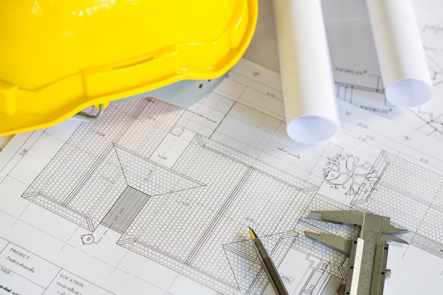 Les plans de construction avec casque jaune et des outils de dessin sur bluep