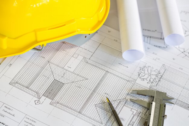 Les plans de construction avec casque jaune et des outils de dessin sur bluep