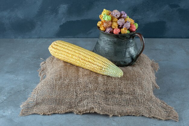 Plant de maïs et popcorns aromatisés colorés dans un pot métallique. photo de haute qualité