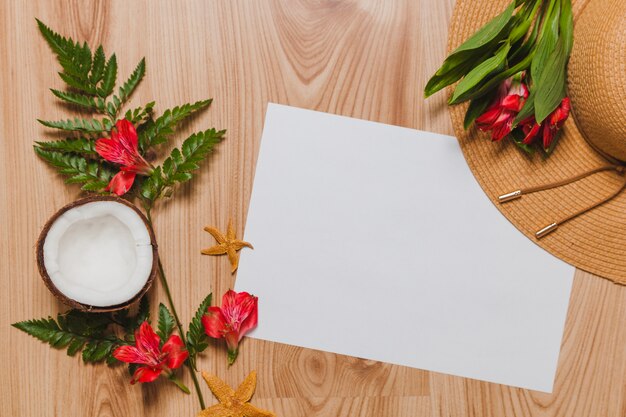 Plantes exotiques, noix de coco, chapeau et papier blanc