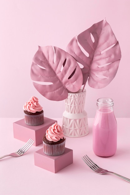 Photo gratuite plantes de monstera et cupcakes roses