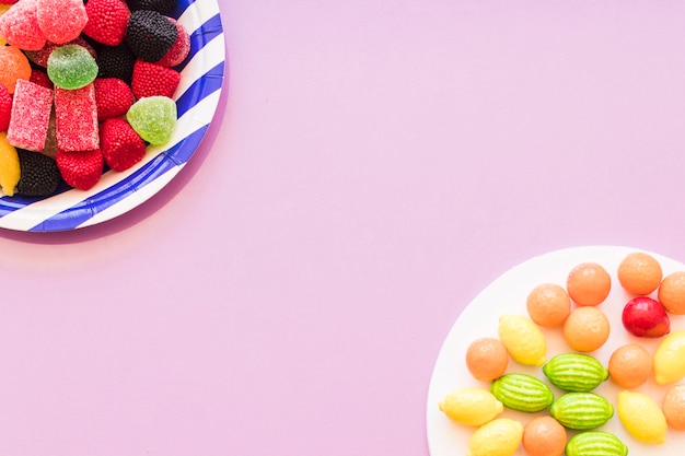 Photo gratuite plaque de bonbons colorés sur le coin de fond rose