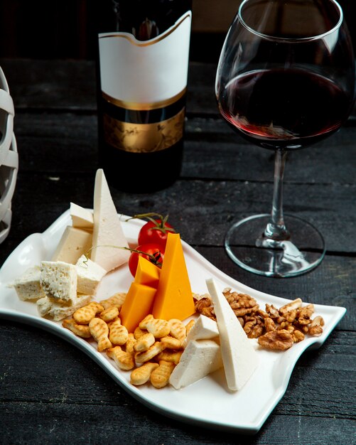 Plaque de fromage avec un verre de vin rouge