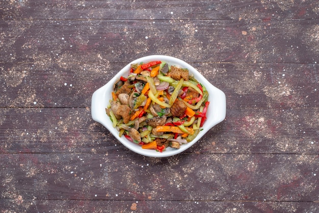 Plat de viande en tranches avec des légumes cuits à l'intérieur de la plaque sur bois brun, viande de légumes repas alimentaire