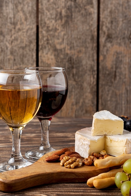 Plateau en bois avec assortiments de fromages pour dégustation de vins