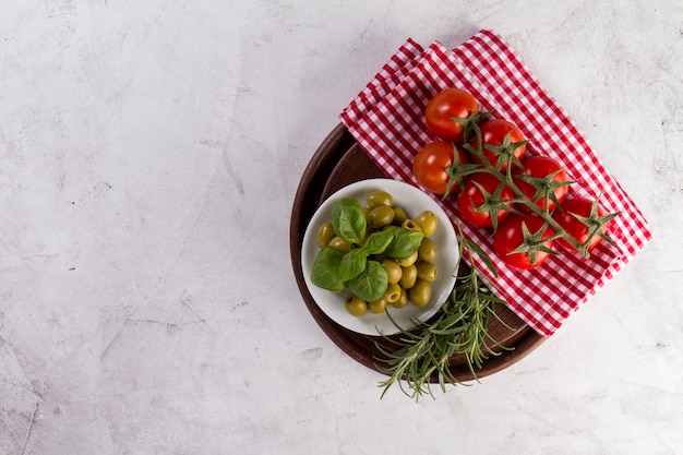 Photo gratuite plateau en bois avec des olives, tomates et romarin