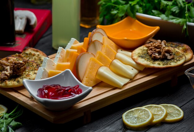 Plateau de fromages avec variations de fromages, craquelins, noix et confiture de fraises