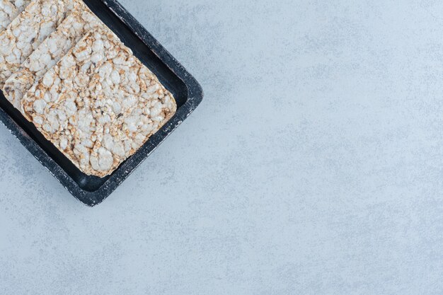 Un plateau de galettes de riz soufflé sur marbre.