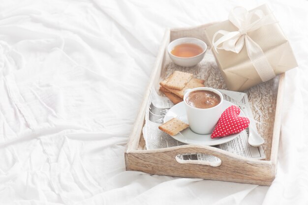 plateau de petit déjeuner avec un café, un coeur et un cadeau d&#39;or