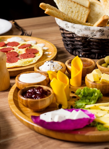 Plateau de petit déjeuner avec confitures fromage beurre olives yaourt