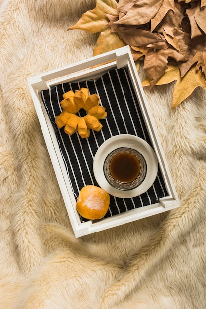 Photo gratuite plateau avec petit déjeuner près des feuilles