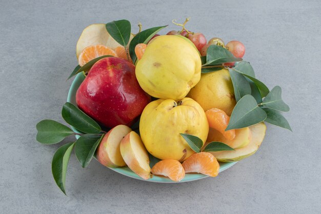 Un plateau avec un tas de fruits assortis sur marbre