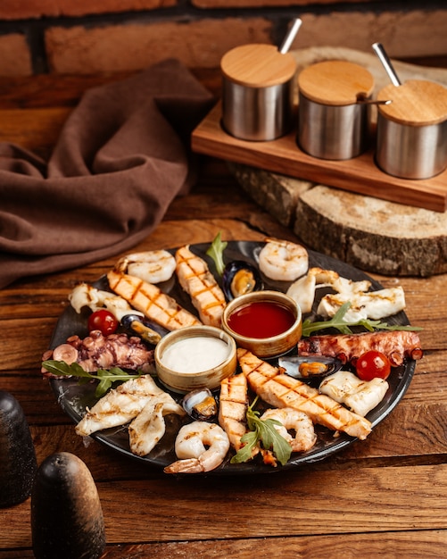 Photo gratuite un plateau de vue de dessus avec des plats de viande et de poisson de nourriture avec différentes sauces sur le bureau en bois brun cuisine de viande de repas de nourriture