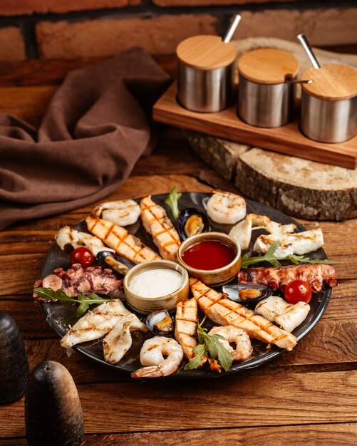 Un plateau de vue de dessus avec des plats de viande et de poisson de nourriture avec différentes sauces sur le bureau en bois brun cuisine de viande de repas de nourriture