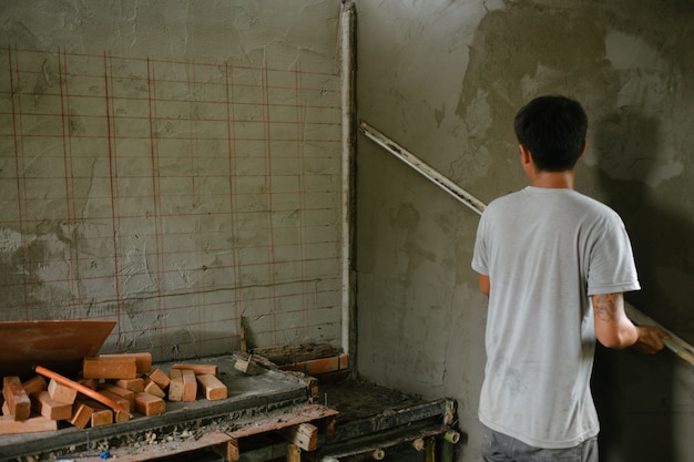 Photo gratuite plâtrier rénovant les murs intérieurs.