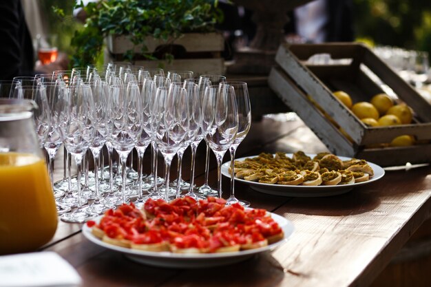 Plats blancs avec des sandwichs debout sur une table en bois avant vide