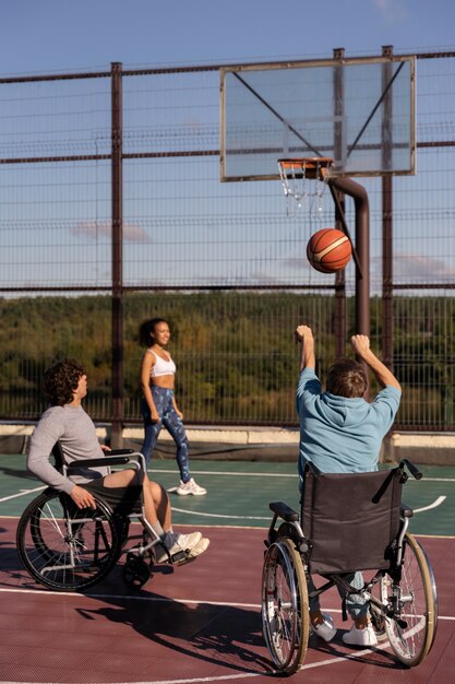 Plein d'amis jouant au basket-ball à l'extérieur