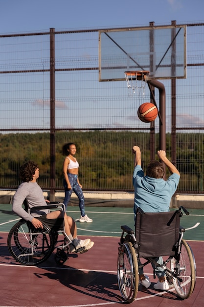 Plein d'amis jouant au basket-ball à l'extérieur