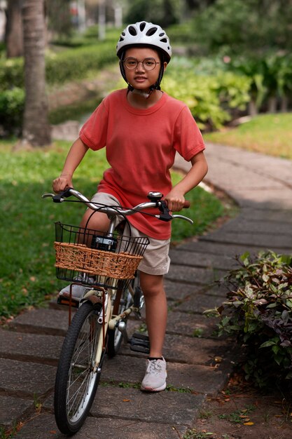 Photo gratuite plein coup d'enfant faisant du vélo à l'extérieur