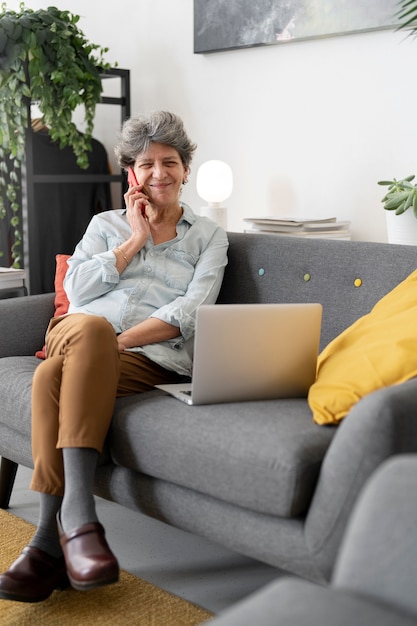 Plein coup femme âgée assise sur un canapé