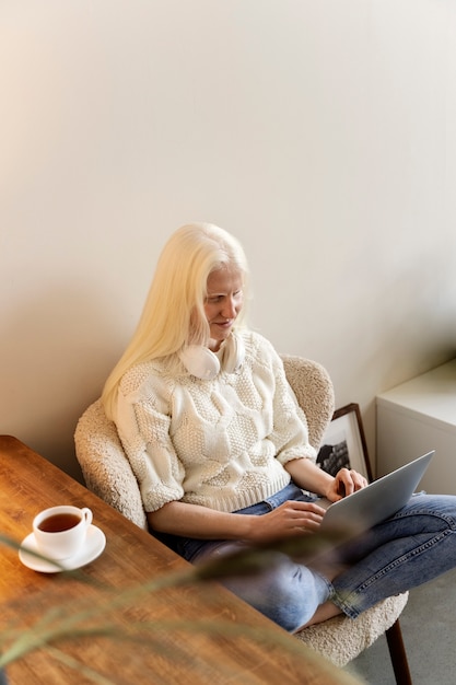 Photo gratuite plein coup femme albinos travaillant sur ordinateur portable