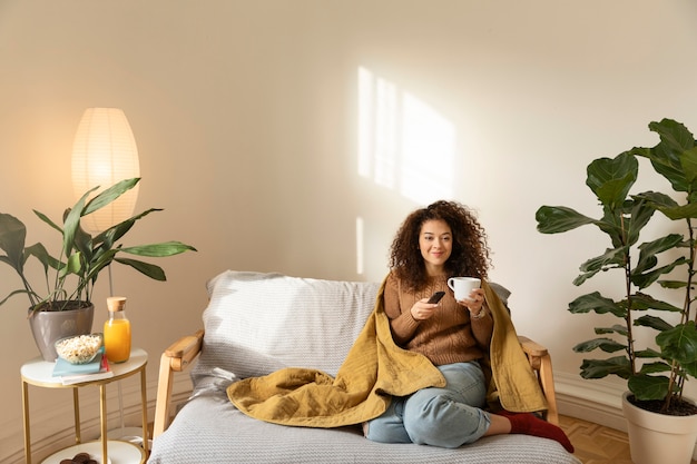 Plein coup femme assise sur un canapé