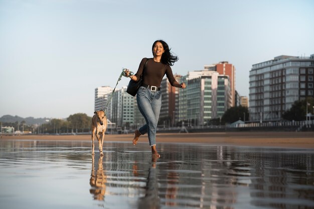 Plein coup femme avec chien lévrier à l'extérieur