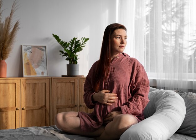 Plein coup femme enceinte assise à la maison