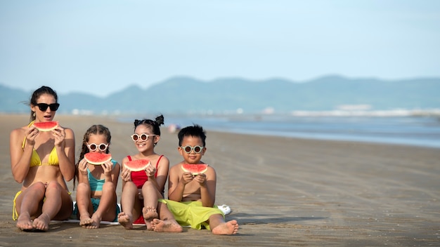 Photo gratuite plein coup femme et enfants mangeant de la pastèque