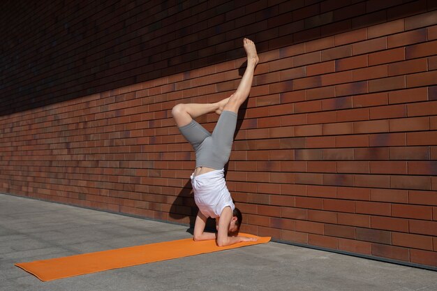 Plein coup femme faisant du yoga avec mur