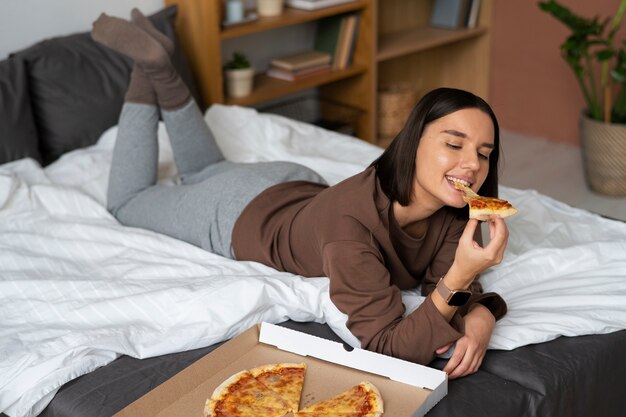 Plein coup femme mangeant de délicieuses pizzas