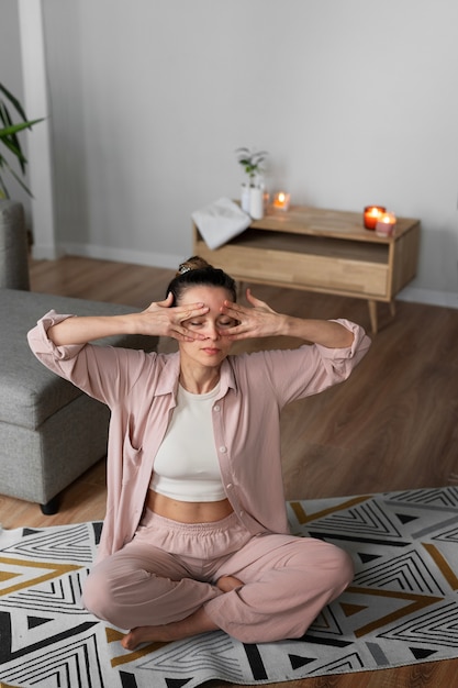 Photo gratuite plein coup femme pratiquant le yoga facial