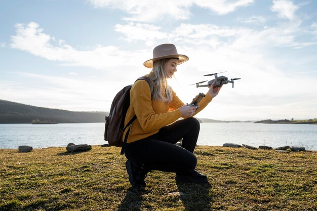 Plein coup femme tenant un drone à l'extérieur