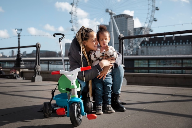 Photo gratuite plein coup femme tenant un enfant à l'extérieur