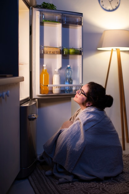 Photo gratuite plein coup femme vérifiant le réfrigérateur pour une collation