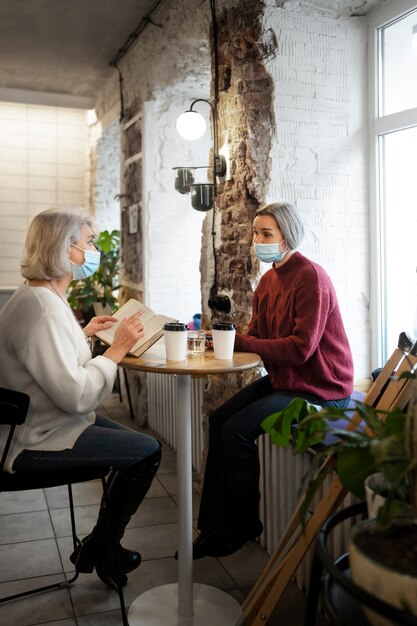 Plein coup de femmes assises à table à l'intérieur