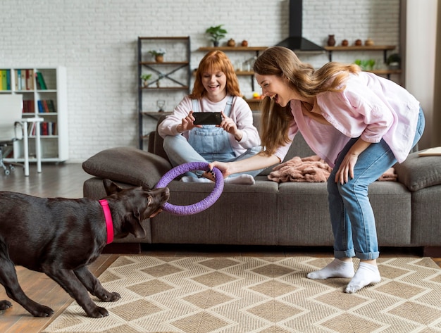 Photo gratuite plein coup de femmes et de chien à l'intérieur