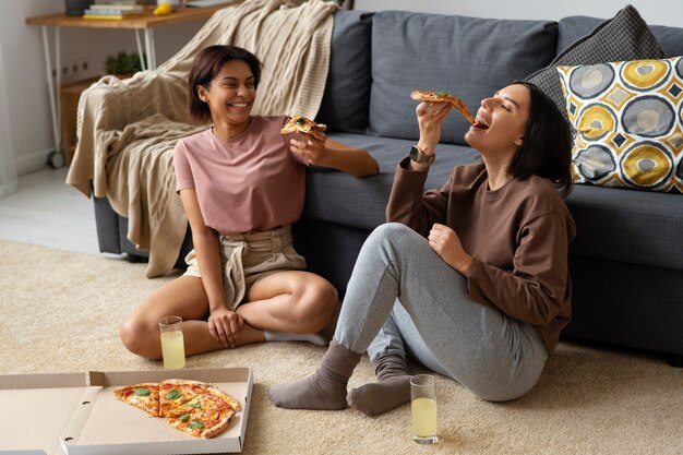 Plein coup de femmes mangeant de délicieuses pizzas