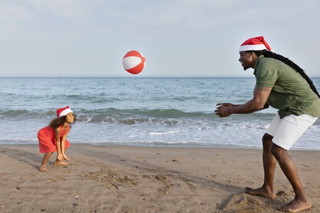 Plein coup fille et homme jouant avec un ballon sur la plage