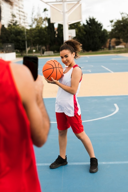 Plein coup de fille posant avec ballon de basket