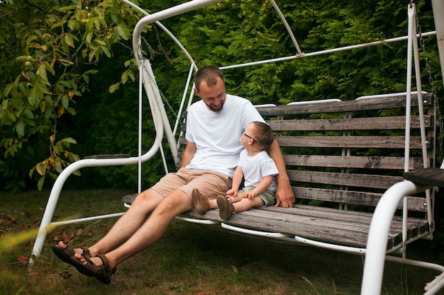 Photo gratuite plein coup garçon et enfant assis sur un banc